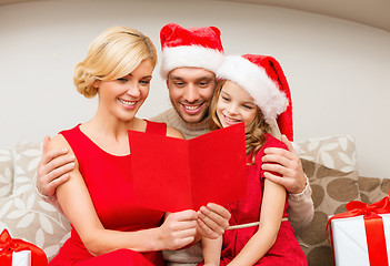 Image showing smiling family reading postcard