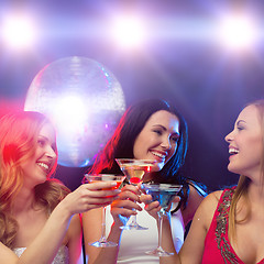 Image showing three smiling women with cocktails and disco ball