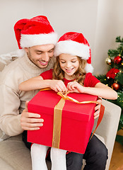 Image showing smiling father and daughter opening gift box