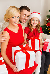 Image showing smiling family holding many gift boxes