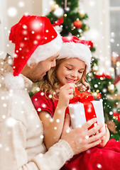 Image showing smiling father and daughter opening gift box