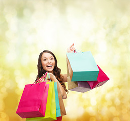 Image showing woman in red dress with colorful shopping bags