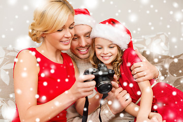 Image showing family in santa helper hats looking at pictires