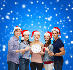 Image showing group of smiling students with clock showing 12