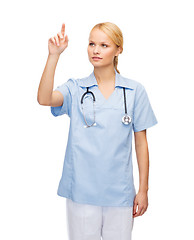 Image showing smiling doctor or nurse pointing to something