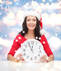 Image showing woman in santa helper hat with clock showing 12