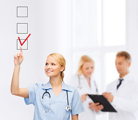 Image showing doctor or nurse drawning checkmark into checkbox