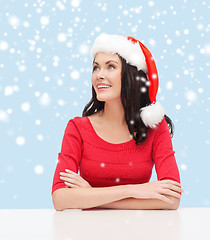 Image showing surprised woman in santa helper hat looking up