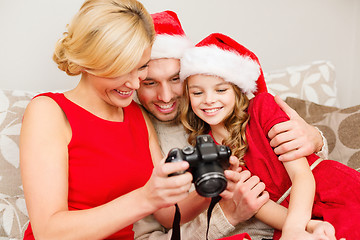 Image showing family in santa helper hats looking at pictires