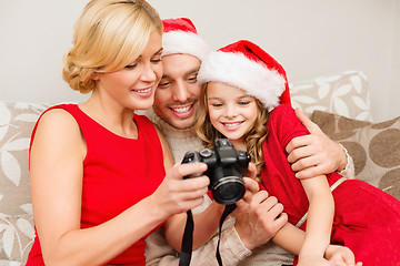 Image showing family in santa helper hats looking at pictires