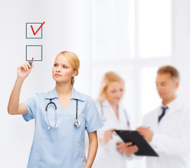 Image showing doctor or nurse drawning checkmark into checkbox