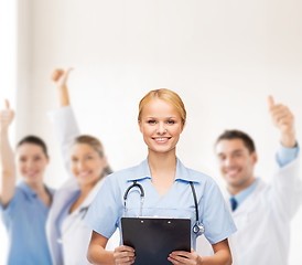 Image showing smiling female doctor or nurse with clipboard