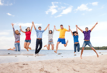 Image showing group of friends jumping on the beach