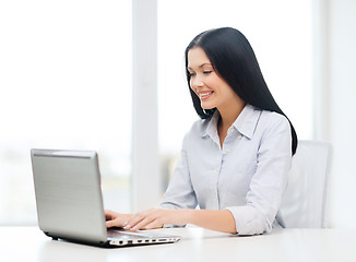 Image showing smiling businesswoman or student with laptop