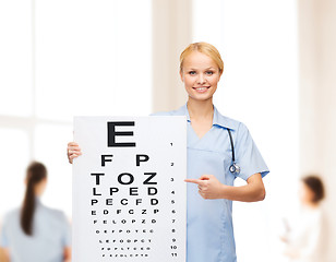 Image showing smiling female doctor or nurse with eye chart