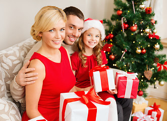 Image showing smiling family holding many gift boxes