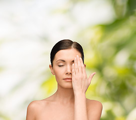 Image showing calm young woman covering face with hand