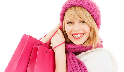 Image showing woman in pink hat and scarf with shopping bags