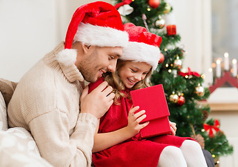 Image showing smiling father and daughter opening gift box