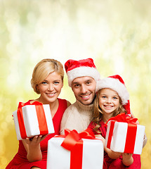 Image showing smiling family giving many gift boxes