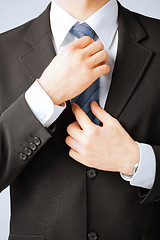 Image showing man adjusting his tie