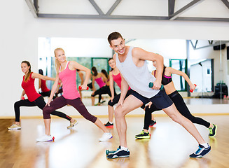 Image showing group of smiling people working out with dumbbells