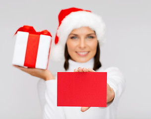 Image showing smiling woman in santa helper hat with postcard