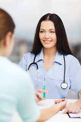 Image showing smiling female doctor or nurse with syringe