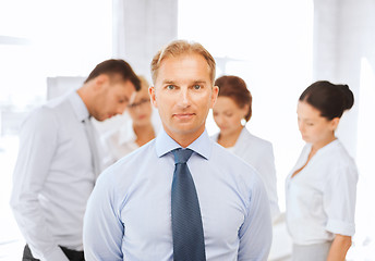 Image showing businessman in office with group on the back