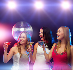 Image showing three smiling women with cocktails and disco ball