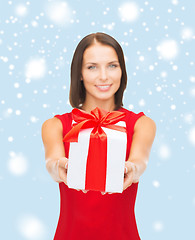 Image showing smiling woman in red dress holding gift box