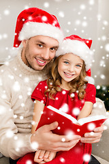 Image showing smiling father and daughter reading book