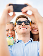 Image showing group of friends taking picture with smartphone