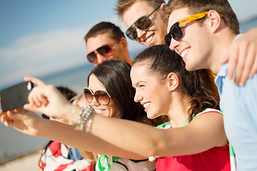 Image showing group of friends taking picture with smartphone