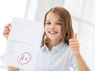 Image showing smiling little student girl with test and A grade