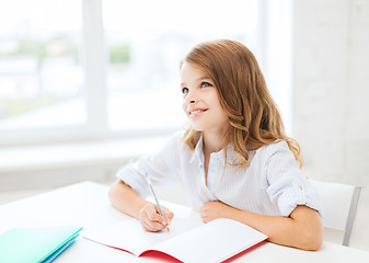 Image showing student girl writing in notebook at school