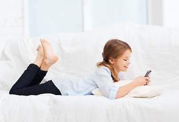 Image showing smiling girl with smartphone at home