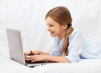 Image showing smiling girl with laptop computer at home