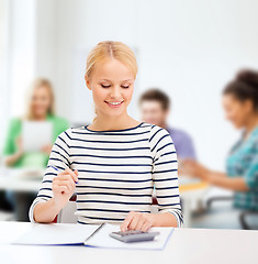 Image showing woman with notebook and calculator studying