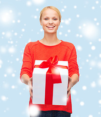 Image showing smiling woman in red sweater with gift box