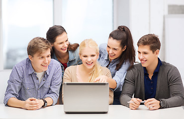 Image showing smiling students looking at laptop at school