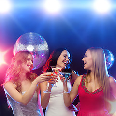 Image showing three smiling women with cocktails and disco ball