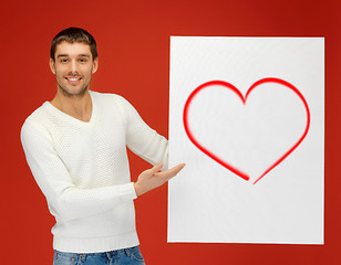 Image showing handsome man holding big board with heart