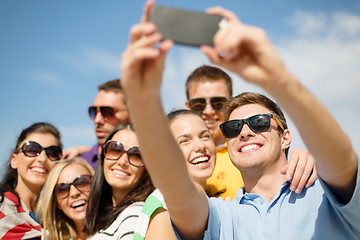 Image showing group of friends taking picture with smartphone