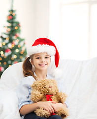 Image showing smiling girl in santa helper hat with teddy bear