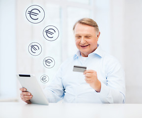 Image showing old man with tablet pc and credit card at home