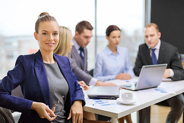 Image showing businesswoman with glasses with team on the back