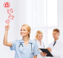 Image showing smiling doctor or nurse pointing to envelope