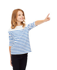 Image showing smiling girl pointing at virtual screen