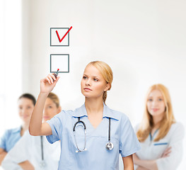 Image showing doctor or nurse drawning checkmark into checkbox